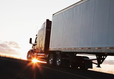 silhouette-of-a-commercial-truck-driving-on-a-highway-at-sunset-.jpg